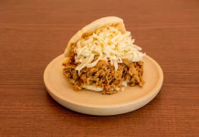 Delicada explösión de sabor criollo: descubre por qué la arepa rellena de carne mechada y queso amarillo es un clásico insuperable de la gastronomía venezolana
